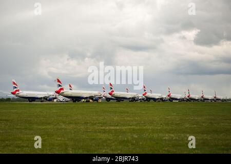 Glasgow, Großbritannien. April 2020. Im Bild: Gewitterwolken sammeln sich, als die Bodencrews von British Airways die Sammlung von 14 geerdeten Flugzeugen des Typs Airbus A319/A320 & A321 in Betrieb nehmen, die seit Beginn der Sperrung des Coronavirus (COVID-19) auf der zweiten Start- und Landebahn des Flughafens Glasgow geparkt wurden. Die globale Luftfahrtindustrie ist seitdem in eine Kernschmelze geritten, einige Fluggesellschaften gehen in die Pleite und andere wie BA bitten um staatliche finanzielle Unterstützung. Bis heute hat BA angekündigt, dass es fast 12,000 Mitarbeiter zu nehmen. Quelle: Colin Fisher/Alamy Live News Stockfoto