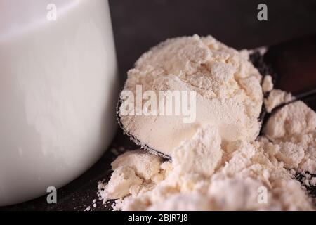 Haufen von Protein-Pulver mit Löffel auf dem Tisch, Nahaufnahme Stockfoto