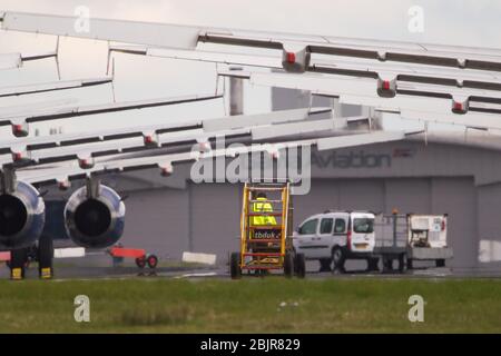 Glasgow, Großbritannien. April 2020. Im Bild: Gewitterwolken sammeln sich, als die Bodencrews von British Airways die Sammlung von 14 geerdeten Flugzeugen des Typs Airbus A319/A320 & A321 in Betrieb nehmen, die seit Beginn der Sperrung des Coronavirus (COVID-19) auf der zweiten Start- und Landebahn des Flughafens Glasgow geparkt wurden. Die globale Luftfahrtindustrie ist seitdem in eine Kernschmelze geritten, einige Fluggesellschaften gehen in die Pleite und andere wie BA bitten um staatliche finanzielle Unterstützung. Bis heute hat BA angekündigt, dass es fast 12,000 Mitarbeiter zu nehmen. Quelle: Colin Fisher/Alamy Live News Stockfoto