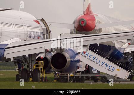 Glasgow, Großbritannien. April 2020. Im Bild: Gewitterwolken sammeln sich, als die Bodencrews von British Airways die Sammlung von 14 geerdeten Flugzeugen des Typs Airbus A319/A320 & A321 in Betrieb nehmen, die seit Beginn der Sperrung des Coronavirus (COVID-19) auf der zweiten Start- und Landebahn des Flughafens Glasgow geparkt wurden. Die globale Luftfahrtindustrie ist seitdem in eine Kernschmelze geritten, einige Fluggesellschaften gehen in die Pleite und andere wie BA bitten um staatliche finanzielle Unterstützung. Bis heute hat BA angekündigt, dass es fast 12,000 Mitarbeiter zu nehmen. Quelle: Colin Fisher/Alamy Live News Stockfoto