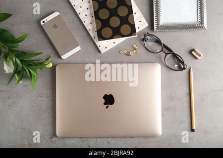 KIEW, UKRAINE - 24. OKTOBER 2017: Apple MacBook Gold und iPhone SE Gold auf grauem Hintergrund, Draufsicht Stockfoto