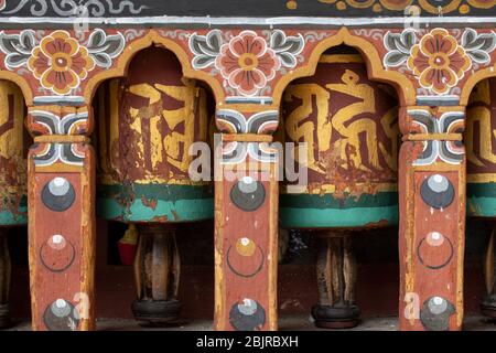 Paro, Bhutan. Rinpung Dzong, buddhistisches Kloster und Festung. Detail der traditionellen verzierten Bhutanese Hand geschnitzten hölzernen Gebetsräder. Stockfoto