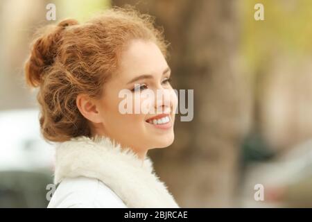 Schöne lächelnde Frau in Jacke mit Kunstfell Kragen im Freien Stockfoto