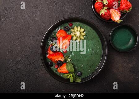 Bunte, gesunde Lebensmittel. Acai Smoothie Schüssel. Keto Frühstücksidee. Fruit Quark Smoothie, acai. Frühstück mit grünen Spirulina, Erdbeere, Chia, Kiwi in Stockfoto