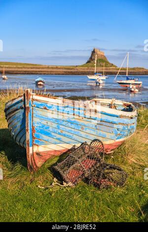 Ein Boot am Ufer der Heiligen Insel mit Lindisfarne Castle im Hintergrund, England Stockfoto