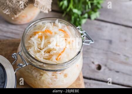 Sauerkraut fermentierter Salat. Hausgemachter frischer, eingelegter Kohl (deutsches Sauerkraut) mit Zutaten im Glas Stockfoto