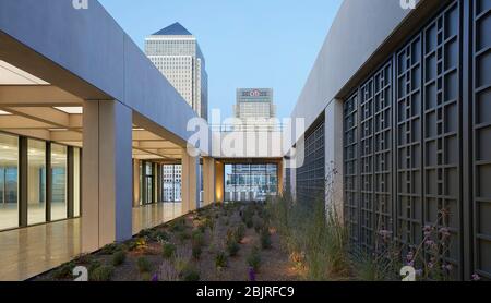 Obere Außenterrasse mit Garten, Blick auf 1 Canada Square. 25 Cabot Square, London, Großbritannien. Architekt: Carmody Groarke, 2019. Stockfoto