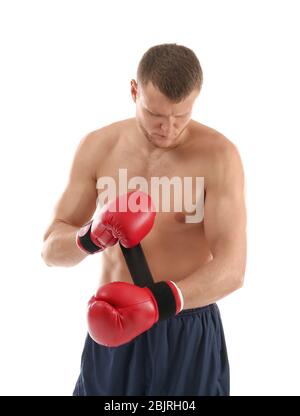 Attraktiver junger Mann, der Boxhandschuhe auf weißem Hintergrund anlegt Stockfoto