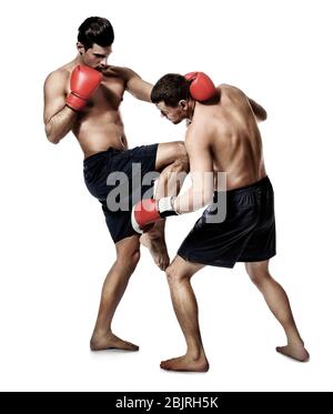 Attraktive junge Kickboxer kämpfen auf weißem Hintergrund Stockfoto