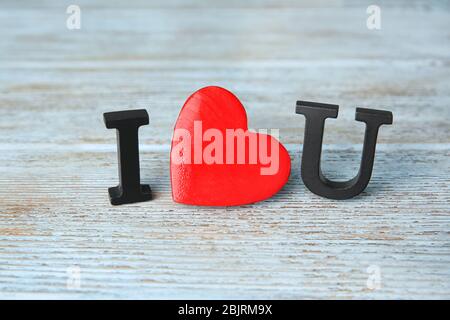 Satz 'Ich liebe dich' mit rotem Herz und Buchstaben auf Holzhintergrund gemacht Stockfoto