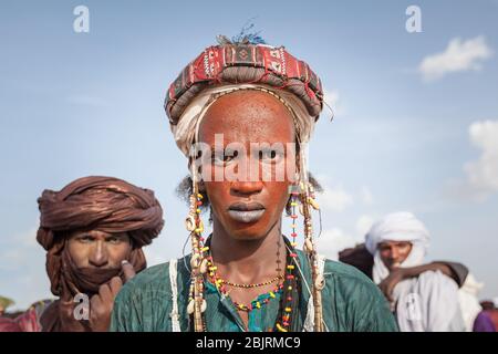 Ingall, Niger : Fulani Bororo Wodaabe Nomaden Schönheitswettbewerb Afrikanischer Mann Porträt in bunten traditionellen Kleidung beim Curee Sale Festival Stockfoto