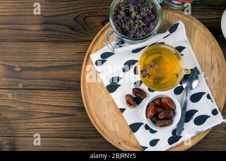 Tee mit Minze im arabischen Stil und Datteln auf Holztisch. Von oben mit viel Platz Stockfoto