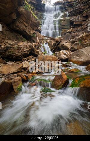 Die unteren Wasserfälle des Butcher Branch in der New River Gorge stürzen sich durch eine große Steinmauer, bevor sie dem New River unten begegnen. Stockfoto