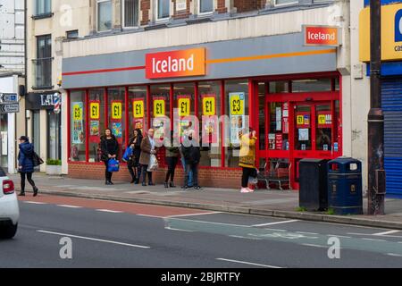 Während der COVID-19-Pandemie stellen sich die Käufer vor einem isländischen Supermarkt in die Schlange Stockfoto