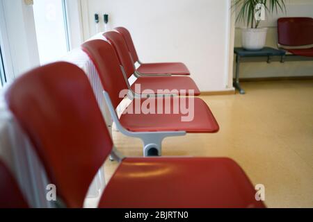 Wartezimmer mit roten Stühlen und beigefarbenem Linoleum-Fußboden Stockfoto