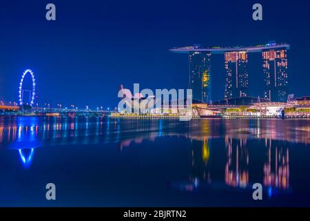 Nacht Singapur. Ruhe über Marina Bay. Berühmtes Hotel, ArtScience Museum und Riesenrad Stockfoto