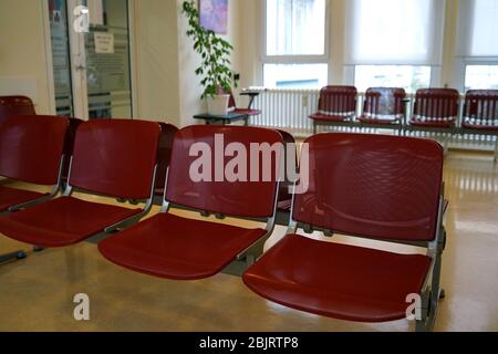 Wartezimmer mit roten Stühlen und beigefarbenem Linoleum-Fußboden Stockfoto