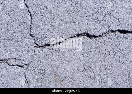 Straßenbelag, Straßenpflaster, Risse im Asphalt. Auflösung alten Betonzement mit Rissen und natürliche Zerstörung von Zeit und Wetterbedingungen Stockfoto