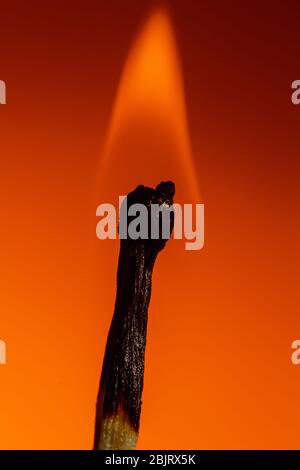 Verbranntes Spiel in den Kohlen und Feuer auf üppigen Lava Hintergrund. Nahaufnahme Kopierraum Stockfoto