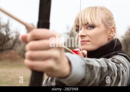 Attraktive Frau Bogenschießen im Freien üben Stockfoto