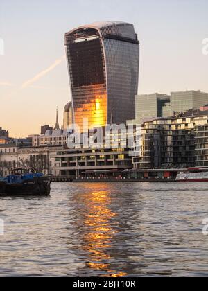 Die untergehende Sonne, die sich im Gebäude der Fenchurch Straße 20, besser bekannt als Walki Talki, spiegelt sich im Wasser des Flusses Stockfoto