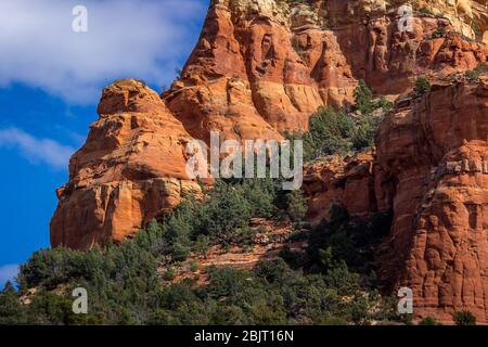 Detaillierte Ansicht des Capitol Butte (aka Thunder Mountain) Red Rock Formation aus Dry Creek Vista an einem sonnigen Tag mit blauen Himmel und Wolken, Sedona, Arizona Stockfoto