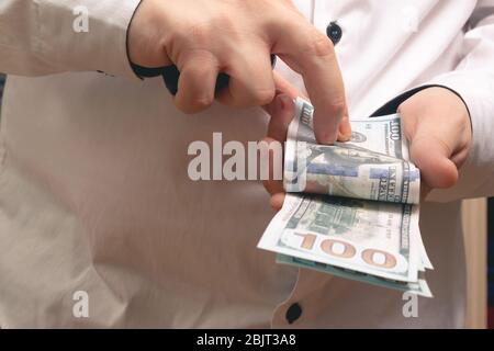 Kaukasischer Mann zählt Geld hundert Dollar-Rechnungen in einem weißen Hemd im Büro Stockfoto