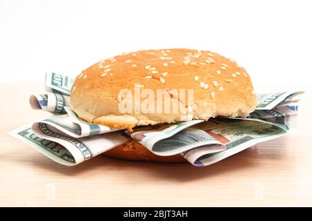 burger mit hundert Dollar-Scheinen statt auf einem Holzbrett zu füllen, Seitenansicht Stockfoto