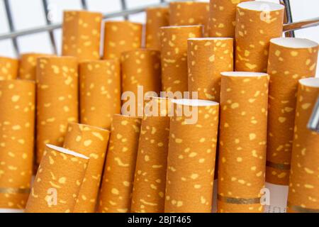 Zigarettenfilter aus orangen Zigaretten mit einem goldenen Band Stockfoto