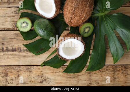 Zusammensetzung mit frischen Kokosnüssen und tropischen Früchten auf grünem Blatt Stockfoto