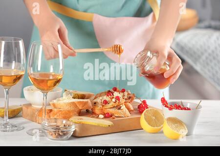 Frau bereitet köstliche Bruschettas auf dem Tisch Stockfoto