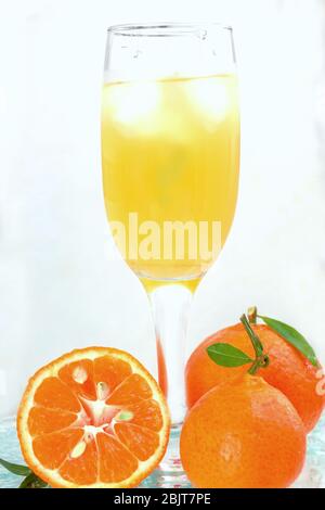 Glas Champagner mit Cocktail, Saft mit Eis Mandarinen mit lmstochkami auf Glas Licht Hintergrund Stockfoto