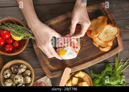 Frau bereitet köstliche Bruschettas auf dem Tisch Stockfoto