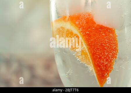 Glas mit Orangen, Eis, Mineralwasser aus der Nähe Stockfoto