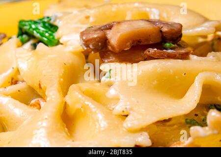 Butterfly Pasta mit gebratenen Pilzen, grünem Spinat Stockfoto