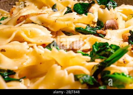 Butterfly Pasta mit gebratenen Pilzen, grünem Spinat Stockfoto