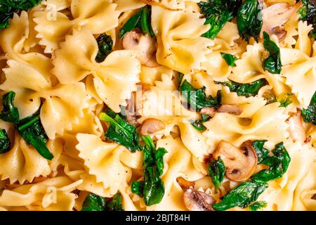 Butterfly Pasta mit gebratenen Pilzen, grünem Spinat Stockfoto