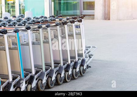 Eine Reihe von Gepäckwagen für Passagiere am Eingang zum Flughafenterminal Stockfoto