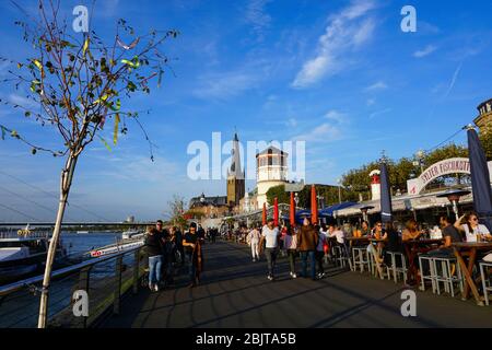 Panoramablick auf die Rheinpromenade in der Altstadt - warmer Abend und spätnachmittags Sonne. Die Rheinpromenade ist eine der Hauptattraktionen. Stockfoto