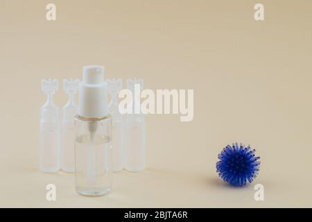 Abstraktes Modell des Coronavirus, Ampulle mit Medizin und Flasche mit antibakteriellem Gel für Hände auf beigem Hintergrund. Hygienekonzept. Stockfoto