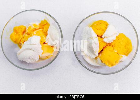 Zwei Vanilleeis mit Mango, Pfirsich auf hellem Hintergrund, selektiver Fokus Stockfoto