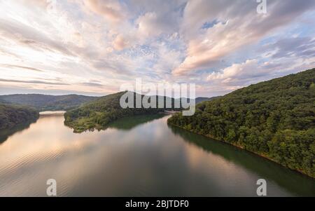 Eine Luftaufnahme des Stonewall Jackson Lake und des Damms im fernen Vordergrund mit Wolken über dem Kopf bei Sonnenuntergang. Stockfoto