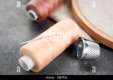 Nähgarn mit Nadel und Handfalle auf dem Tisch Stockfoto