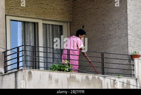 Wanderarbeiterin putzt den Balkon ihrer Arbeitgeber-Wohnung, im Osten Beiruts, Libanon. Stockfoto