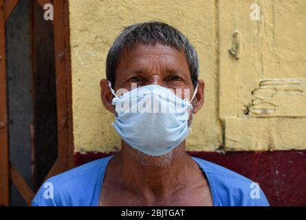 Guwahati, Assam, Indien. April 2020. Eine Arbeit mit Gesichtsmaske, die vor einem geschlossenen Geschäft während der landesweiten Sperrung nach der Coronavirus-Pandemie in Guwahati sitzt. Kredit: David Talukdar/ZUMA Wire/Alamy Live News Stockfoto