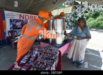 Guwahati, Assam, Indien. April 2020. Mitarbeiter der National Disaster Response Force (NDRF) verteilen während der landesweiten Lockdown im Zuge der Coronavirus-Pandemie in Guwahati Lebensmittel an bedürftige Menschen. Kredit: David Talukdar/ZUMA Wire/Alamy Live News Stockfoto