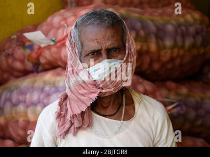 Guwahati, Assam, Indien. April 2020. Eine Arbeit, die Gesichtsmaske trägt, die in einem Kartoffelkrümmchen sitzt, während der landesweiten Sperrung im Zuge der Coronavirus-Pandemie in Guwahati. Kredit: David Talukdar/ZUMA Wire/Alamy Live News Stockfoto