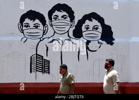 Guwahati, Assam, Indien. April 2020. Polizeipersonal steht vor einem Wandbild mit Maske, während der landesweiten Sperrung im Zuge der Coronavirus-Pandemie in Guwahati. Kredit: David Talukdar/ZUMA Wire/Alamy Live News Stockfoto