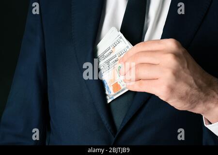 Geschäftsmann, der Bestechung in die Tasche stecken, Nahaufnahme Stockfoto