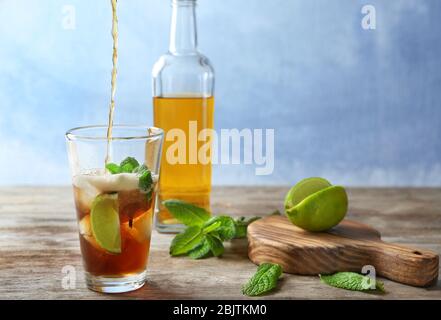 Cola in Glas gießen mit Cuba Libre Cocktail auf dem Tisch Stockfoto